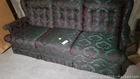 Front view of the green brocade tufted 3 cushion sofa showing floral pattern upholstery and overall shape.
