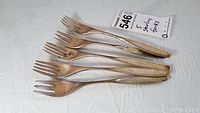 Five tarnished sterling silver forks from S. Kirk and Sons displayed on a white surface.