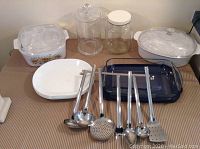 Photo showing casserole dishes, glass jars, plates, baking dish and metal utensils