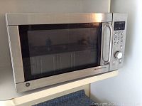 Front view of the GE Microwave Browner with stainless steel door and window.