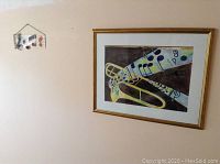 View of watercolour painting and stained glass art on wall showing both items in lot