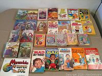 Lot of 29 vintage children's books laid out on table showing variety of titles and colorful covers.