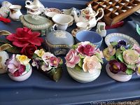 Overall view of the assorted floral china pieces, jewelry holders, small plates, and flower figurines arranged on a tray
