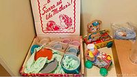 Overall view of toy tea set with pastel teacups, saucers, plates inside box with original packaging.