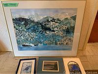 Full view of large framed mosaic with three smaller framed items and decorative plate in front