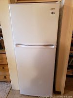 Front view of closed white Simplicity refrigerator with MaxSold lot sticker showing dimensions