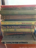 Stack of vintage school books titles visible on spines.