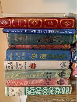 Stack of vintage hardcover classic books mostly with titles visible on spines including The White Cliffs and Kim.