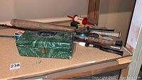 Overview of the fishing rods, tackle box, baseball bats and a vintage hockey puck.