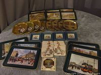 Overview showing the collection of metal serving trays with vintage cityscapes and floral painted trays in various shapes and sizes.