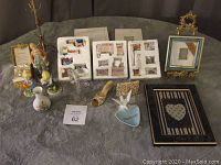 Full view of various Avon miniature furniture and decor items arranged on a surface including framed art, figurines, a miniature shoe, a dove figurine, and decorative trinket boxes.