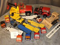 Overview of all vintage Tonka trucks in the lot showing various metal toy trucks including tow truck, dump truck, fire truck, car carriers, and smaller vehicles together.