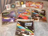 Full view of autographed hockey card, puck, NFL football card box, and NASCAR programs