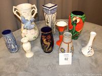 View of all eight vases showing variety of styles and colors including ceramic, wooden, and hand-painted items