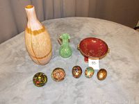 Wooden vase, green glass pitcher, red dish with gold designs, and five assorted glass paperweights.