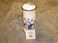 Front view of first vintage General Foods lemonade glass container filled with packing pellets and featuring blue printed child graphic.
