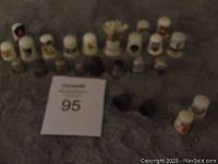 Overview image of all 20 thimbles including glass and metal types arranged in rows with a lot number card visible.