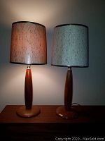 Pair of lamps illuminated on sideboard showing overall style and shades
