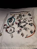Overview of lot showing multiple pieces including chain bracelets, beaded and metal bracelets, various rings, and multiple pairs of earrings.