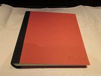 Photo album closed showing orange and black cloth cover with embossed 'Photos' text.