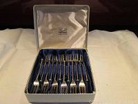 Set of 12 silver cocktail forks in original box with blue lining and cream satin lid.
