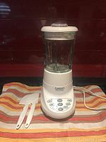 Front view of Cuisinart Smart Power 7 speed blender on cloth with two spatulas in front.