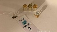 Overview photo showing Swarovski crystal baby carriage, crystal butterfly, and 3 gold-toned salt and pepper shakers.