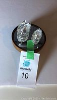 Pair of Swarovski swan figurines displayed on round mirrored wooden stand
