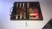 Full view of open backgammon set showing game board, pieces in place and instructional booklet
