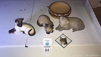 Full lot in white box showing five items: Beswick cat figurine, lidded bowl, reclining dog figurine, small dog figurine, and framed cat face photo.