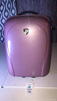 Front view of small pearlized pink Heys suitcase showing logo and curved shell design.
