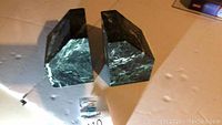 Pair of green marble triangular wedge bookends placed side by side on a white surface.
