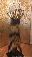 Front view of the metal candle holder showing twisted metal rods and glass candle holders on top.