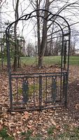 Full front view of metal trellis with gate set among leaves