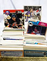 Full front view of grouped hockey cards in box showing multiple players and teams including New York Islanders, Philadelphia Flyers, North Stars, Boston Bruins, and others.
