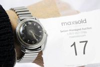 Front view of vintage Hamilton men's watch on wrist with black dial and silver-tone Arabic numerals, showing some scratches on face.