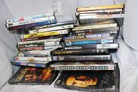 Stack of 33 DVD movie cases showing titles like Happy Feet, Men In Black, Anchorman, Blood Diamonds, Elf, and others in a pile.