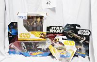 Photo showing all four Star Wars collectible items in original packaging: Hot Wheels die-cast sets and PEZ dispensers with candy packs.