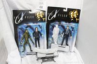 Two original packaging blister cards featuring Dana Scully, Fox Mulder action figures and Alien on gurney accessory, displayed side-by-side against a white backdrop.
