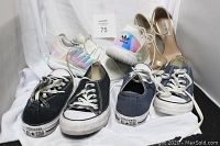 Four pairs of shoes on white cloth background: two Converse All Stars (black and navy blue), Adidas with iridescent panels, and gold high heel sandals by Steve Madden.