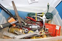 View of plastic tote filled with assorted vintage tools and accessories including pliers, clamps, file, wrench, and a green extension cord