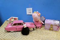 Photo showing all items: pink Cadillac model car, two Betty Boop keepsake boxes, TY Beanie Baby Peppa Pig plush, and piggy furball keychain on a woven surface against blue background.