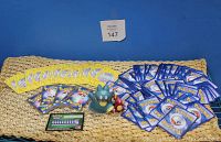 Wide view of the Pokémon card collection arranged with blue rim, yellow 2007 championship cards, and gold rim cards along with two small Pokémon action figures in front, including a blue Munchlax and red Chimchar figure.