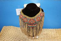 Front-angle photo of the adjustable collar choker necklace showing colorful beadwork and long metal fringe on a black velvet display.