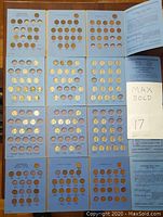 Four blue coin holders arranged including 2 for Canadian pennies and 2 for American nickels, showing multiple coin slots labeled by year and some missing coins.