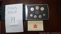 Photo showing the 2002 Canadian Specimen set of coins displayed in a plastic case alongside the certificate of authenticity and MaxSold lot number.