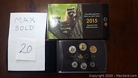 2015 Canadian Specimen Set with coins arranged in a protective case alongside original box showing baby raccoons image and a MaxSold paper.