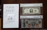 Front view of both graded notes in slabs showing obverse faces and grading labels