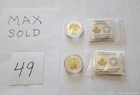 Two coins in clear capsules alongside two sealed informational sleeves for the 2018 $20 First World War and 2017 $25 Great Seal of Canada coins.