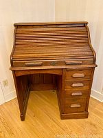 Front view of the antique oak rolltop desk showing the S-shaped tambour top and drawers on the right side.